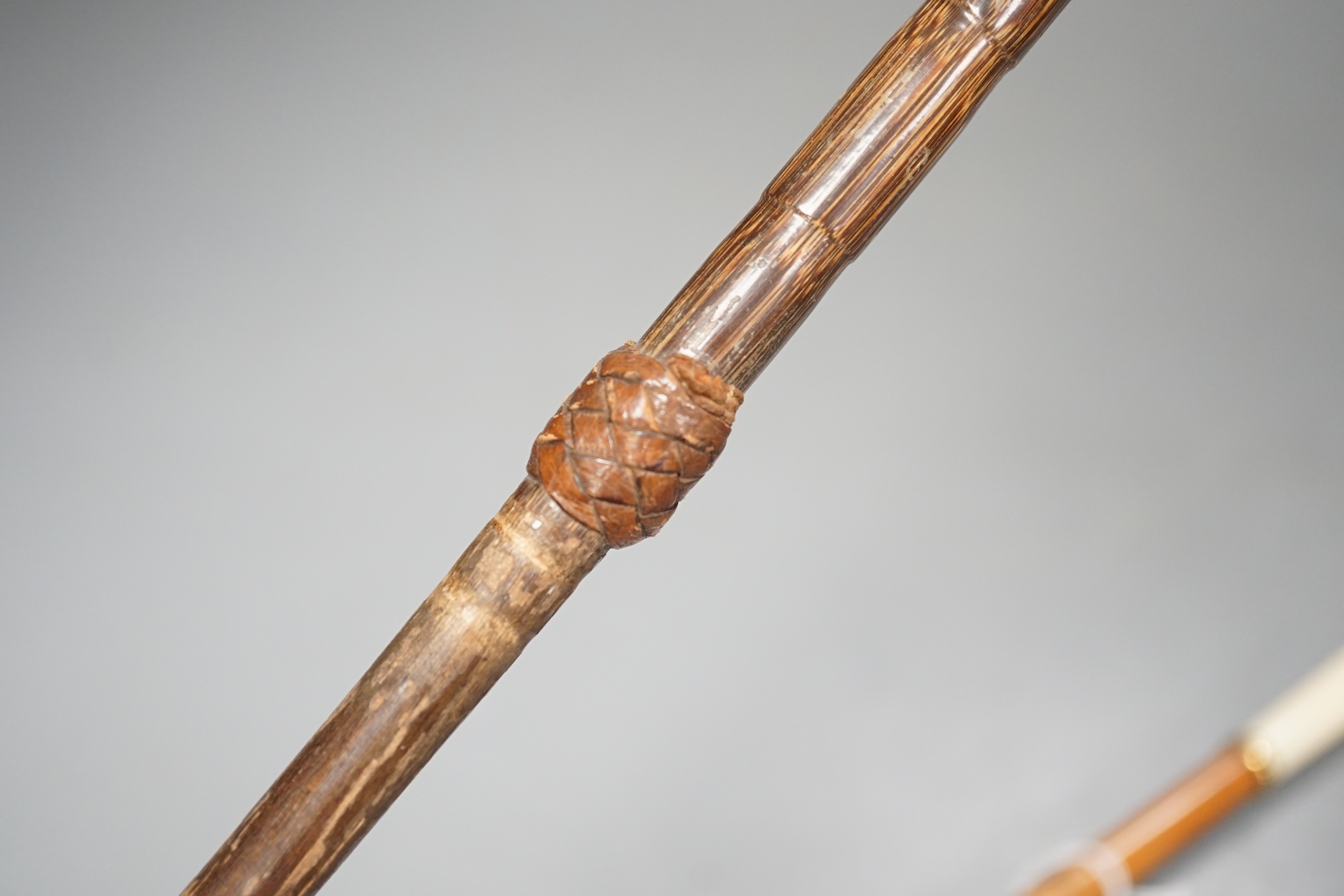 An early 20th century ivory ‘sphinx’ parasol handle, 84cm, together with another gold and iron damascened parasol handle, 62cm